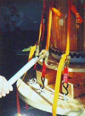 Closeup of a hand in the frame tightening the tension of the drum rig